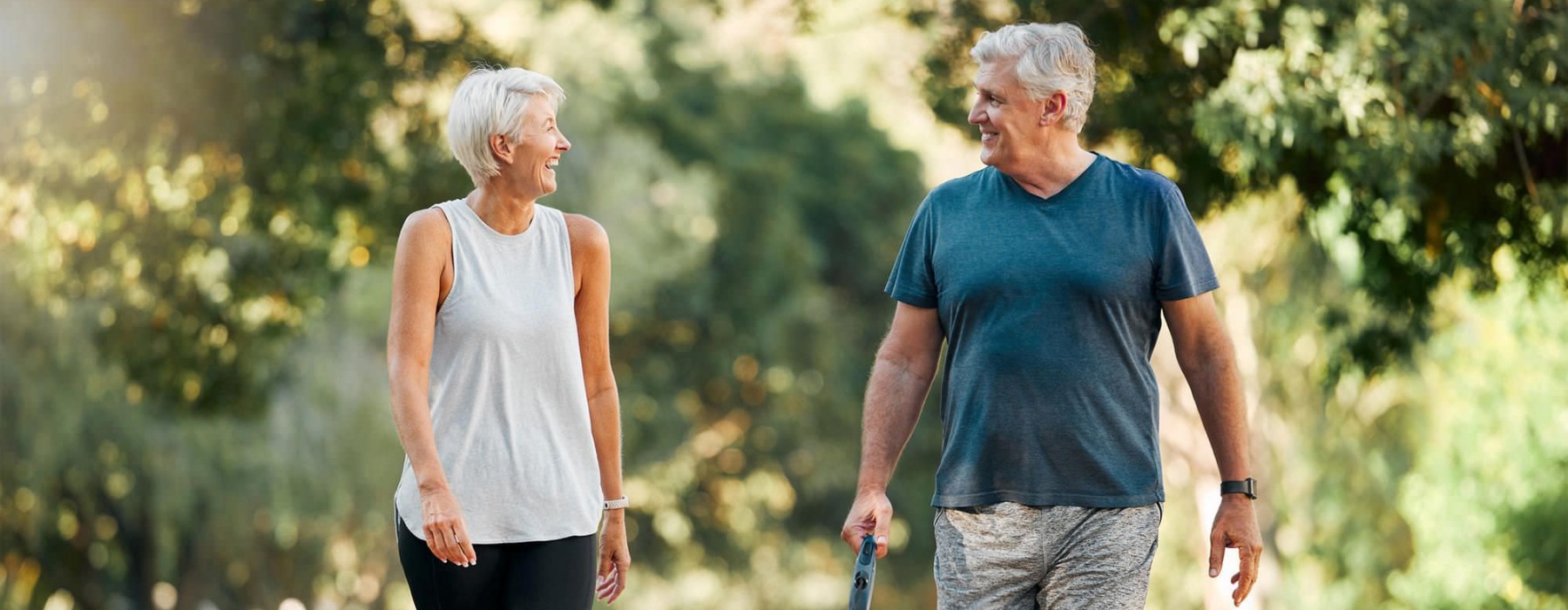 a man and a woman walking a dog on a leash