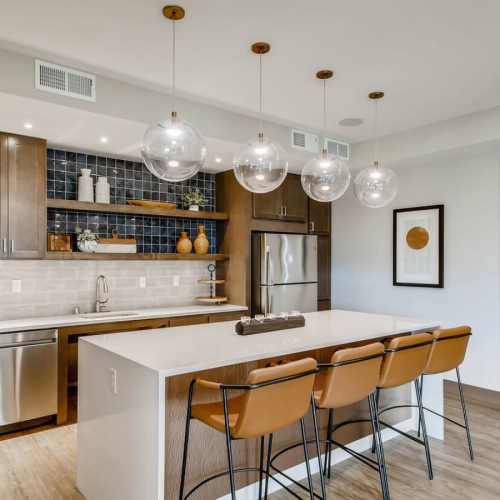 a clubroom kitchen with an island and chairs