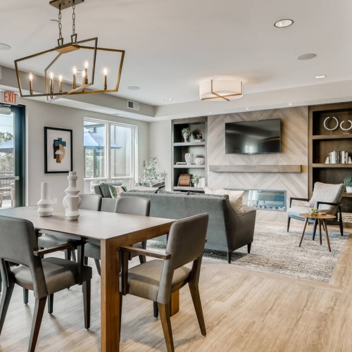a clubroom with a tv, couch, tables and chairs