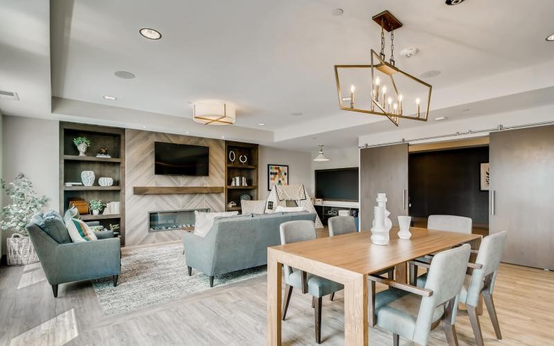 a clubroom with a tv, couch, tables and chairs